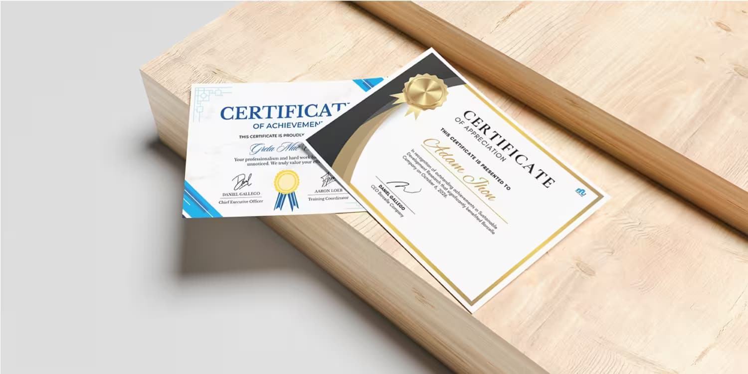 Two custom printed certificates of achievement resting on a light wooden block with gold seals.