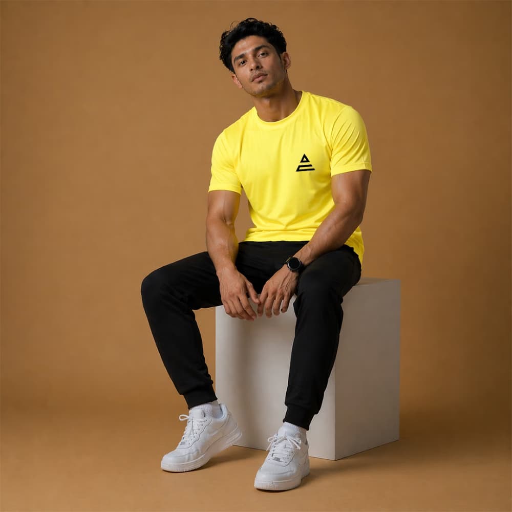 man wearing yellow crew neck sports t shirt in casual studio setting