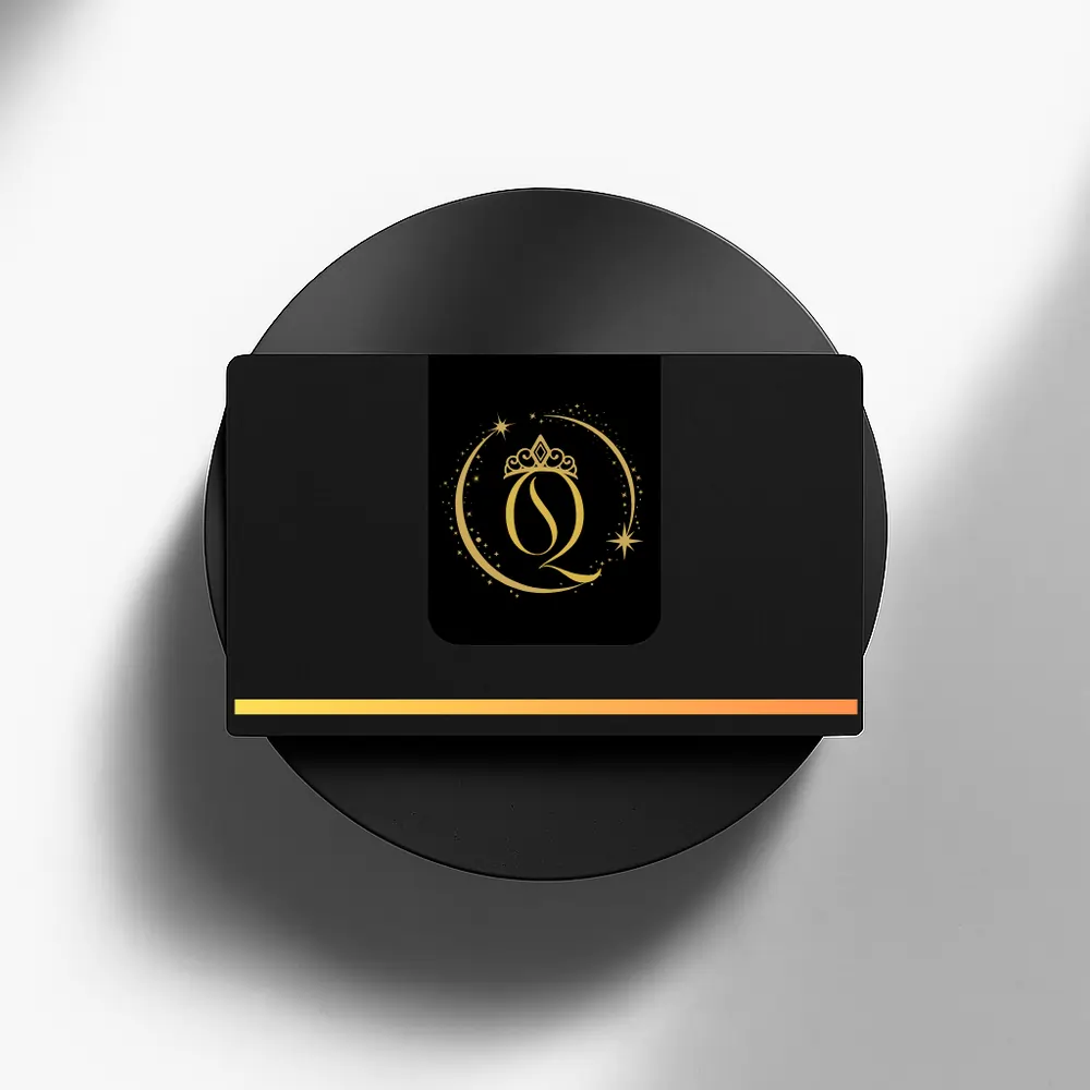 Black business card featuring a gold crowned "Q" logo inside a celestial circle, displayed on a black circular pedestal