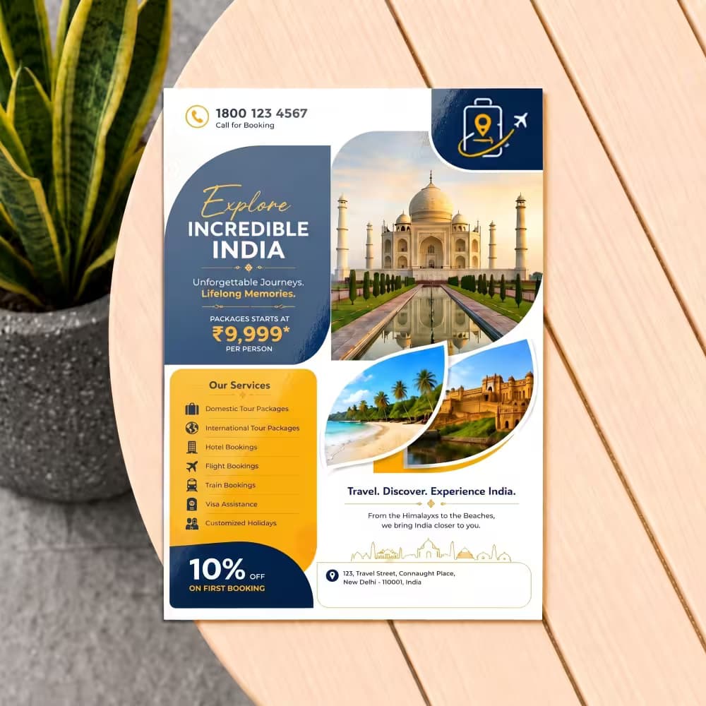 A printed A4 travel flyer with "Explore Incredible India" text and images of the Taj Mahal, beach, and fort on a table.