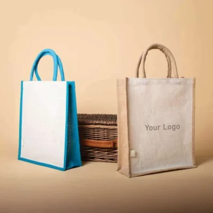 Blue and tan jute bags stand next to a wicker basket, with "Your Logo" placeholder on the tan bag.
