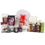 Elegant Luxury Gourmet Chocolate & Snack Gift Hamper showcasing an assortment of delectable treats, including dark chocolate bite-size wafer cookies, handmade almond brittle, and healthy nutty trail mix, all beautifully arranged in a golden basket with a festive red bow.