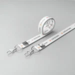 Custom white lanyard with side lever hook, metal clasp, printed ‘DESIGN’ text with orange icon—perfect for office or events.