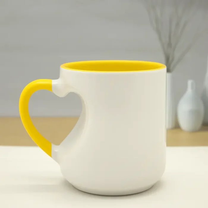 Yellow ceramic custom mug with heart-shaped handle.