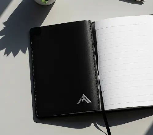 Black diary with lined pages on a desk, showing the benefits of using diaries for planning and notes.