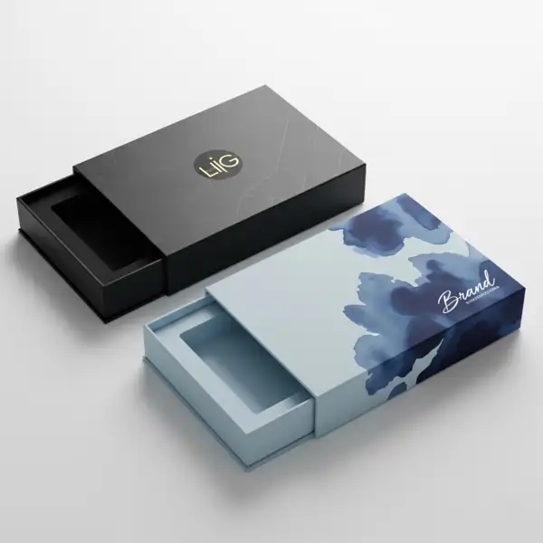 Two elegant, sliding gift boxes. One is black with a gold logo and marble pattern, and the other is light blue with a watercolor design.