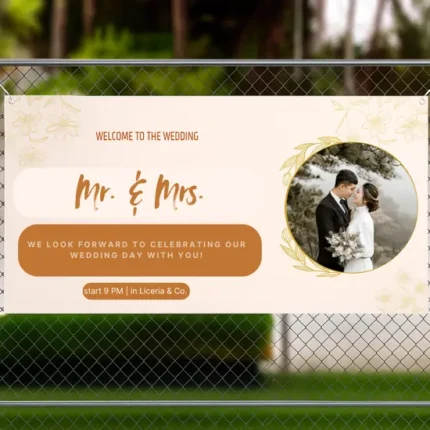 Wedding banner displayed on a fence, featuring “Mr. & Mrs.” text, a photo of the couple, floral accents, and details about the celebration time and venue.