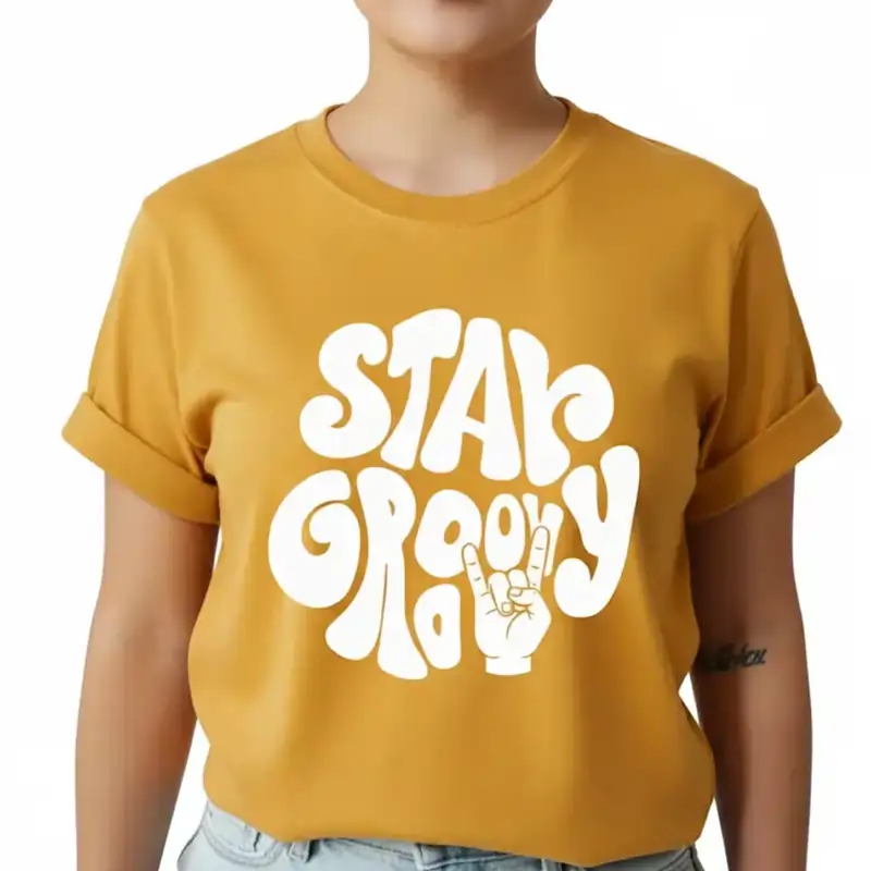 A mustard yellow T-shirt with the white, bubble-letter text "STAY GROOVY" and a rock-on hand sign. Best T-shirt Design Ideas.