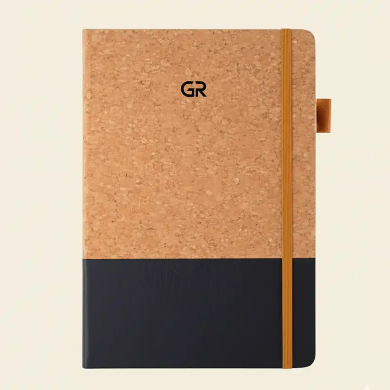 A cork and black leather-bound diary with a black "GR" logo on the cork portion and a light cream background, showcasing one of many Different Types of Diaries.