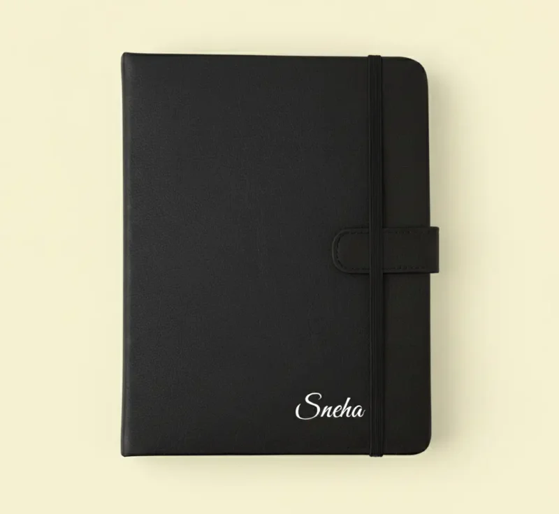 Personalized black leatherette notebook with a name embossed in silver or gold, an ideal stationery item among the best new year gifts for professionals or students.