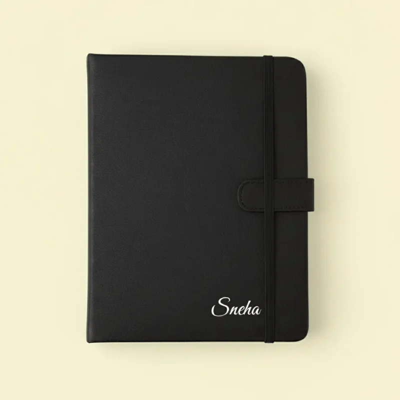 Personalized black leatherette notebook with a name embossed in silver or gold, an ideal stationery item among the best new year gifts for professionals or students.