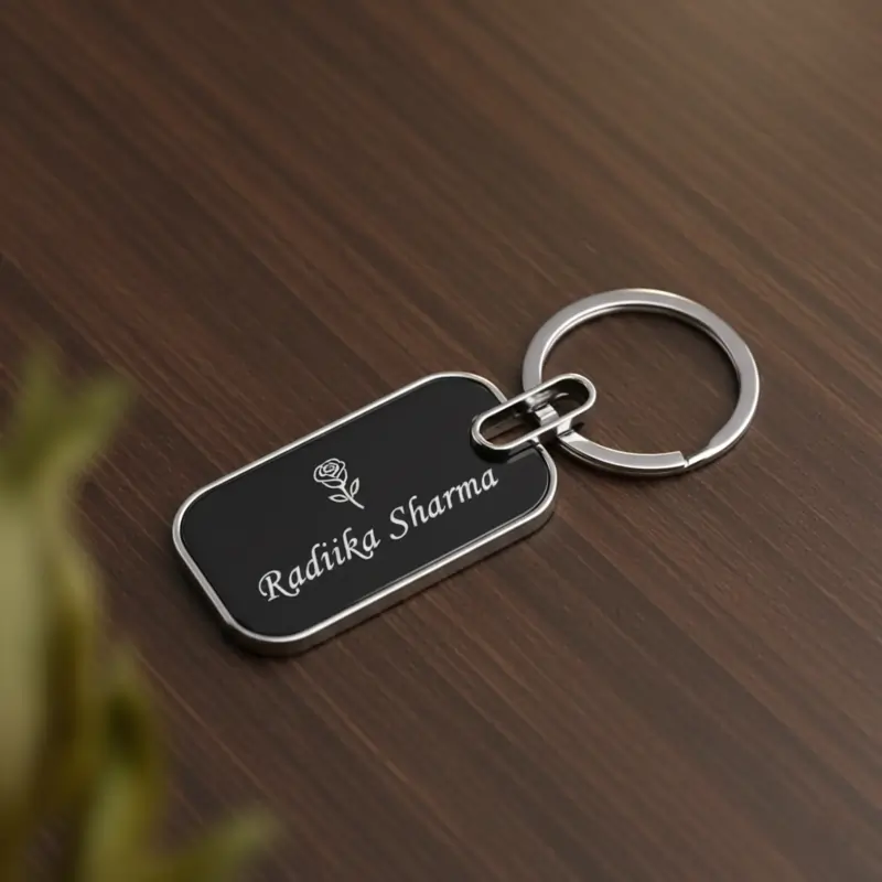 Customized rectangular black metal keychain with a name and decorative design engraved on it, a thoughtful and practical item for the best new year gifts.