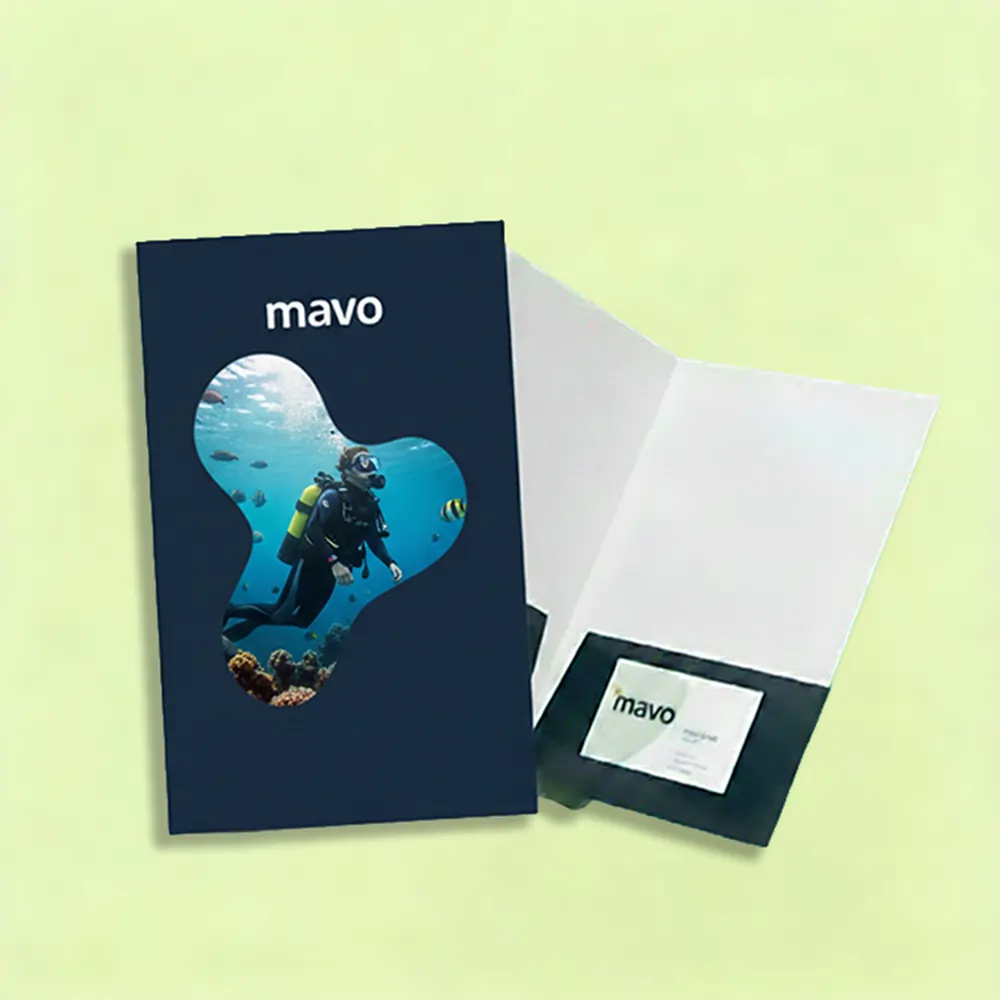 A navy blue pocket folder with a die-cut shape showing a scuba diver underwater and a business card tucked into the inside pocket.
