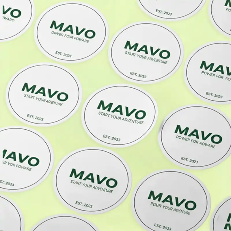 A collection of circular white stickers with the "mavo" logo in dark green and the text "Start Your Adventure, Est. 2023."