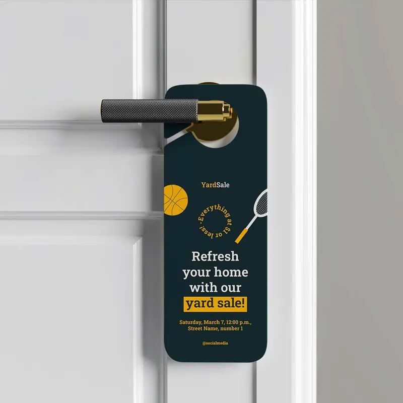 Navy blue Yard Sale promotional door hanger hanging on a white door with gold hardware.