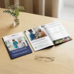Senior care A5 Booklet on a wooden table with glasses and a vase.