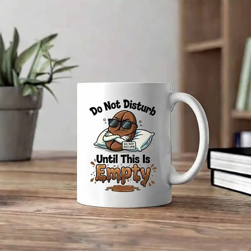 White mug featuring Funny Custom Print Ideas with a grumpy coffee bean in sunglasses saying "Do Not Disturb Until This Is Empty."